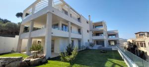 a large white house with a yard at Villasimius Appartamento "Il Ginepro" in Villasimius