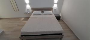 two beds sitting in a room with lights at Villasimius Appartamento "Il Ginepro" in Villasimius +24 photos
