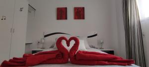 two red towels in the shape of hearts on a bed at La Casilla in Torrenueva