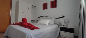 a bedroom with a red blanket on a bed at La Casilla in Torrenueva