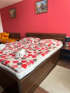 a bed in a bedroom with a red wall at Chata Zemplin in Kaluža