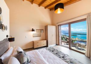 een slaapkamer met een bed en een groot raam bij 180 Villas in Nydri