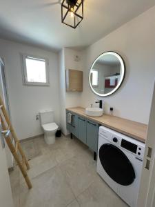 a bathroom with a sink and a toilet and a mirror at Le Lourmarinois in Lourmarin