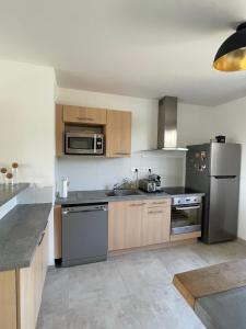 a kitchen with wooden cabinets and stainless steel appliances at Le Lourmarinois in Lourmarin