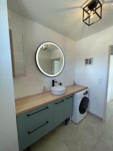 a bathroom with a sink and a washing machine at Le Lourmarinois in Lourmarin +8 photos