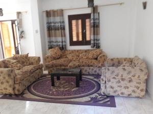 a living room with couches and a table on a rug at Mama Africa in Hurghada