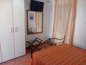 a small bedroom with a bed and a mirror at La casa di Andrea in Favignana