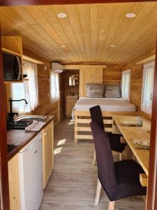 uma pequena cozinha com uma cama num chalé de madeira em Tiny House Roulotte em Cuges-les-Pins