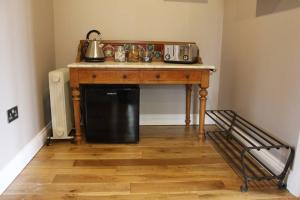 a kitchen with a wooden table with a microwave at Boutique double room with country village views in Wilby