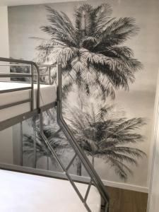 een muurschildering van een palmboom op de muur van een slaapkamer bij DOUCEUR BANDOLAISE in Bandol