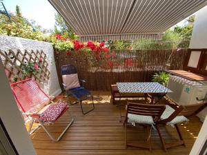 een patio met stoelen, een tafel en een hek bij DOUCEUR BANDOLAISE in Bandol