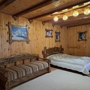 Dos camas en una habitación con paredes de madera. en Зарінок карпат, en Mykulychyn 62 fotos más