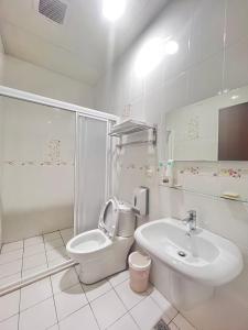 a white bathroom with a toilet and a sink at 永安101 Wing on x 附陽台 in Taitung City