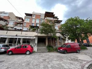 two cars parked in a parking lot in front of a building at Midtown Apartment in Kŭrdzhali