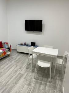 uma sala de estar com uma mesa e uma televisão na parede em Elvis Home em Salerno