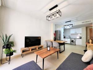 ein Wohnzimmer mit einem TV und einem Tisch in der Unterkunft Apartamento La Gambita de Garrucha in Garrucha