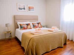 a bedroom with a bed with two towels on it at Pontes Guest House in Arcozelo