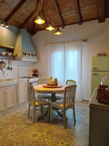 una cucina con tavolo, sedie e frigorifero verde di Habezeiko - The Vintage House ad Áfitos
