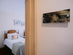 a bedroom with a bed and a painting on the wall at Pontes Guest House in Arcozelo