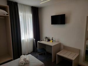 a hotel room with a desk and a television on the wall at IL VITIGNO in Dossobuono