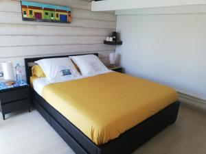 - une chambre avec un lit et une couverture jaune dans l'établissement Studio indépendant chez l'habitant avec piscine et cuisine extérieure, à La Rochelle
