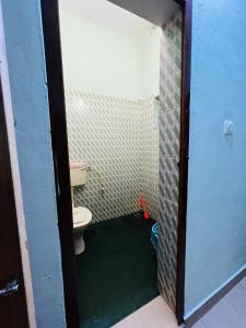 a small bathroom with a toilet in a room at Ocean Pearl in Kozhikode