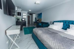 1 dormitorio con 1 cama azul y sala de estar en EnergyApart 26 en Międzywodzie