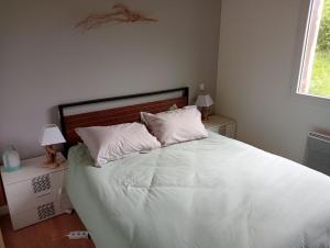 1 dormitorio con 1 cama grande con sábanas y almohadas blancas en Châlet montagne 6 personnes, en Laruns
