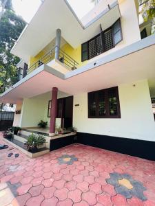 a large yellow and white house with a patio at Ocean Pearl in Kozhikode
