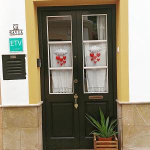 Una puerta verde con dos ventanas con corazones en ellas. en Casa en Ferreries, en Ferreries