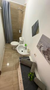 La salle de bains est pourvue d'un lavabo blanc et de toilettes. dans l'établissement Mini House Nane, à Playa Honda