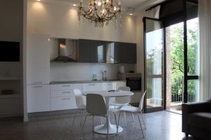 cocina con mesa, sillas y lámpara de araña en la casa di Antoine, en Cesano Maderno