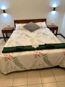 a bed in a bedroom with two night stands at Ambitious Apartment Nadi in Nadi