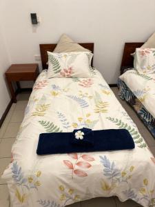 a bed with a blue bow tie on top of it at Ambitious Apartment Nadi in Nadi