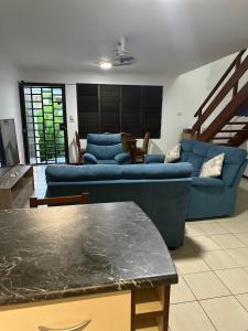 a living room with a blue couch and a table at Ambitious Apartment Nadi in Nadi