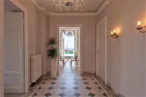 a hallway with a room with a chandelier and a room with a floor at [- Poetic Seafront Penthouse Versilia -] in Massa