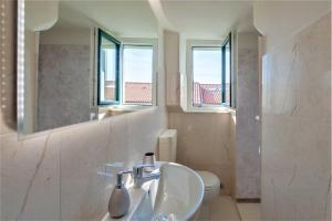 a bathroom with a sink and a toilet and a mirror at [- Poetic Seafront Penthouse Versilia -] in Massa +5 photos