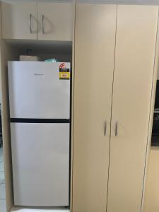 a white refrigerator in a kitchen next to cabinets at Ambitious Apartment Nadi in Nadi