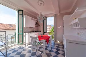a kitchen and dining room with a red table and chairs at [- Poetic Seafront Penthouse Versilia -] in Massa