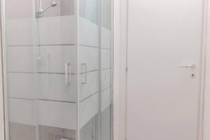 a shower with a glass door in a bathroom at Staurenghi Blue Apartment in Varese