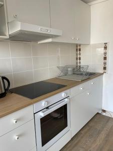 a kitchen with white cabinets and a stove top oven at Spacieux appartement à Blois avec Wifi gratuit in Blois