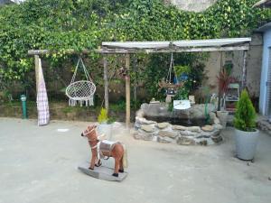a toy horse in a garden with a swing at Pousada Café Country in Petrópolis