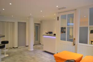 uma sala de estar com um banco laranja e um balcão em Hotel St. Gervais em Genebra