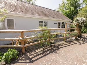 una valla de madera frente a una casa en The Duck House, en Treffgarne