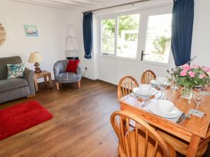 - un salon avec une table et des chaises en bois dans l'établissement The Duck House, à Treffgarne