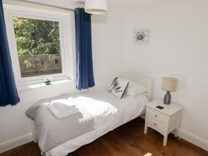 a small bedroom with a bed and a window at The Duck House in Treffgarne