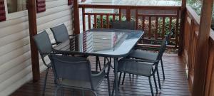 - une table en verre et des chaises sur une terrasse couverte dans l'établissement La Carabasse, à Vias