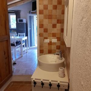 een badkamer met een wastafel en een keuken met een tafel bij Cà di Pippo "Riccio" appartamento Loc Boragni Orco Feglino in Vezzi Portio