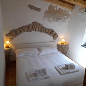 een slaapkamer met een wit bed en 2 handdoeken bij Cà di Pippo "Riccio" appartamento Loc Boragni Orco Feglino in Vezzi Portio