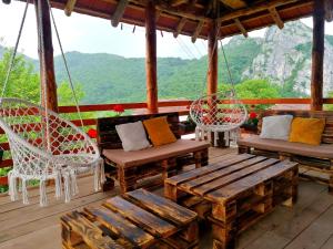 une terrasse couverte avec des chaises et des balançoires sur une montagne dans l'établissement Konak Jerma, à Pirot